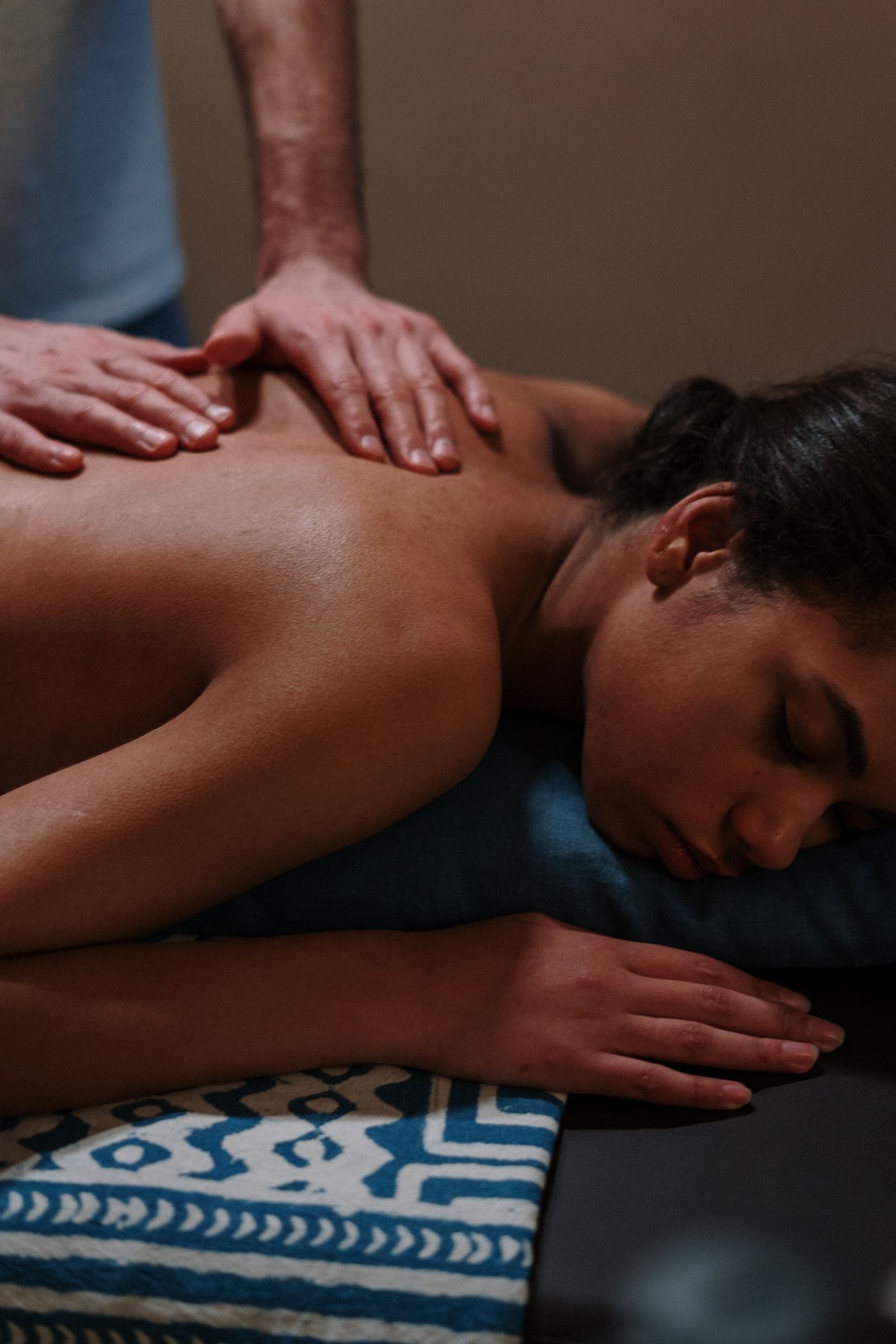 Terapeuta aplicando un masaje de espalda en una camilla
